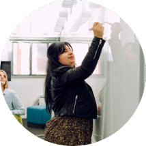 Eine Frau, die auf ein Whiteboard schreibt