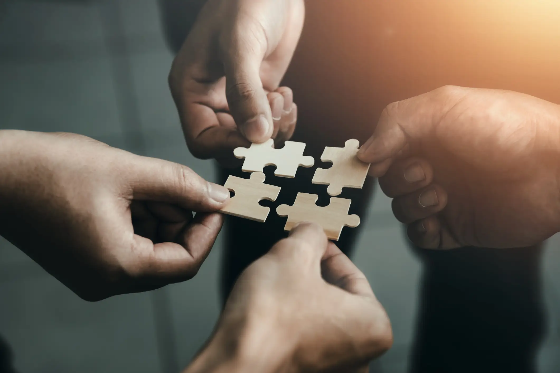 eine Gruppe von Händen, die ein Puzzlestück halten